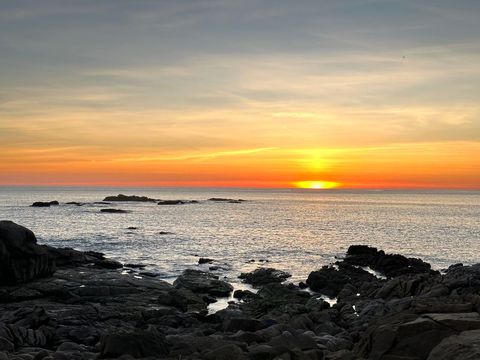 Serene beach sunset over rocky shore