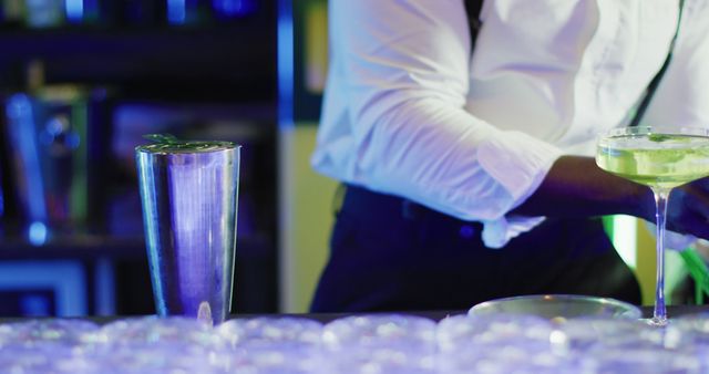 Bartender wearing white shirt preparing sophisticated cocktails in an upscale bar environment. Perfect for illustrating concepts such as nightlife, mixology, bar culture, professional bartending, upscale dining, and cocktail crafting, highlighting the high-end aspect of leisure and service industry.