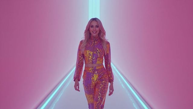 Stylish Model in Neon-lit Corridor Wearing Futuristic Metallic Outfit