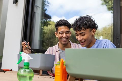 Happy friends enjoy shared gardening activity on patio