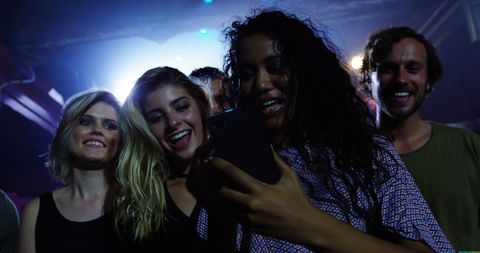 Diverse Group of Friends Enjoying Night Out, Woman Taking Selfie
