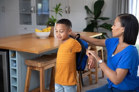 Mother Assisting Son with Backpack for School at Home