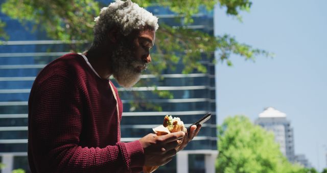 Man Eating Sandwich Outdoors Checking Mobile Phone - Download Free Stock Images Pikwizard.com