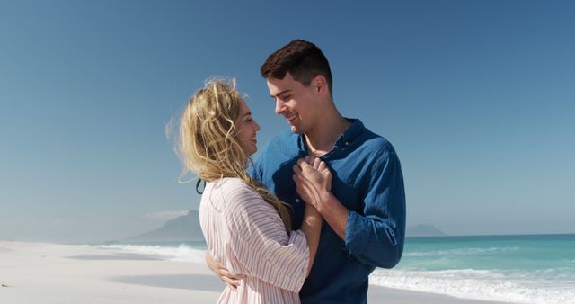 This image shows a couple embracing on a sandy beach with the ocean in the background. The scene evokes feelings of love, romance, and relaxation, making it perfect for use in campaigns about romantic getaways, vacation promotions, or lifestyle blogs focusing on love and relationships.