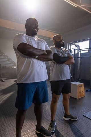 African men standing with arms crossed in gym showing strength and confidence