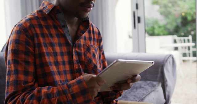 Man Using Tablet at Home in Casual Checkered Shirt - Download Free Stock Images Pikwizard.com