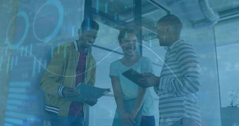 Smiling team collaborating with tablets and documents in glass office blue data overlay