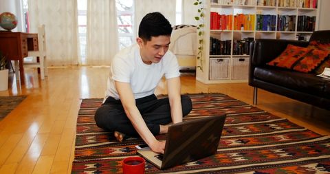 Young Man Working on Laptop in Cozy Home Living Room