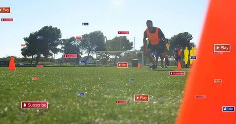Male Athlete Sprinting Low Angle on Soccer Pitch with Training Cones and Social Media Tags