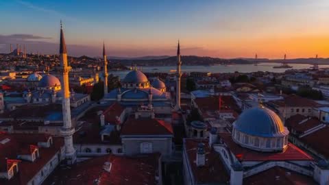 Drone gliding over historic Istanbul domes and minarets at sunset revealing Bosphorus