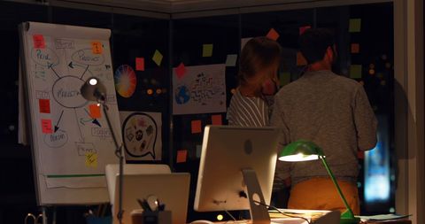 Team Collaboration Brainstorming New Ideas on Office Board at Night