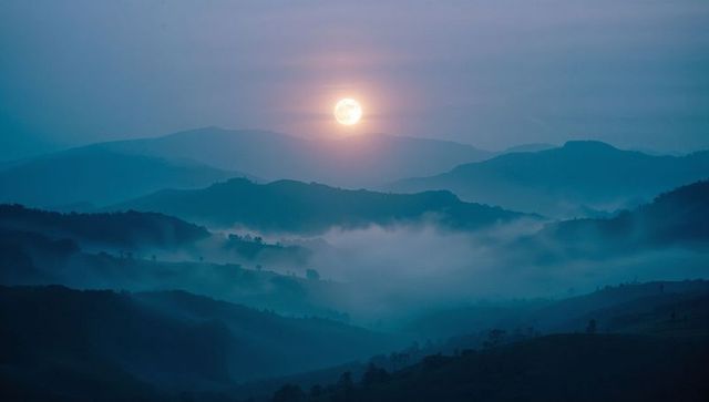 Full Moon Illuminates Misty Valley at Night