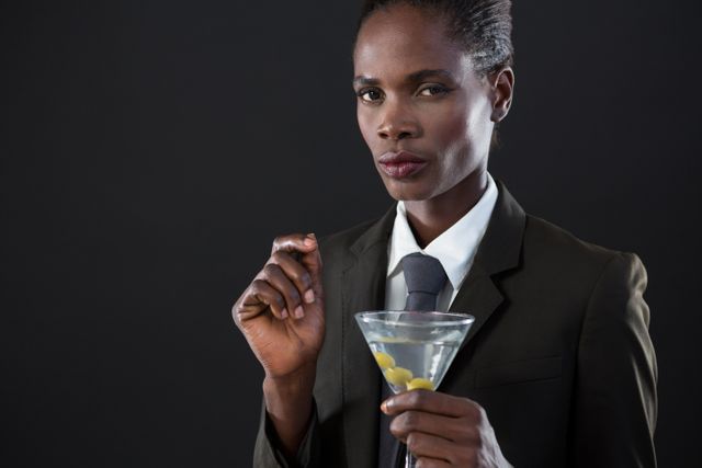 Portrait of androgynous man holding a martini glass