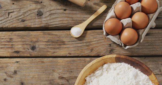 Image of bowl with flour and eggs on wooden surface. baking, food preparing, taste and flavour concept.