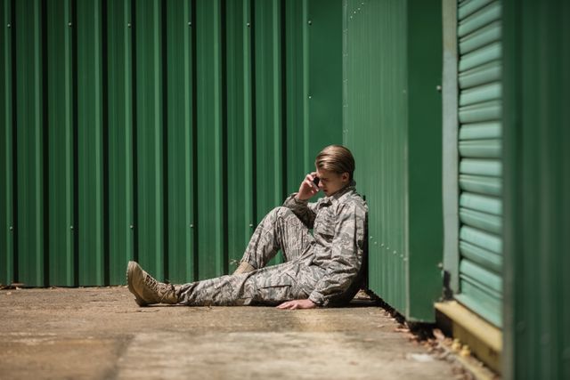 Military soldier talking on mobile phone in boot camp