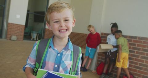 Smiling Boy Holding Notebooks at School Hallway - Download Free Stock Images Pikwizard.com