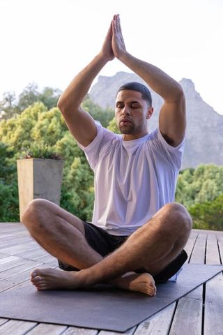 Man Meditating on Yoga Mat Amidst Nature's Tranquility
