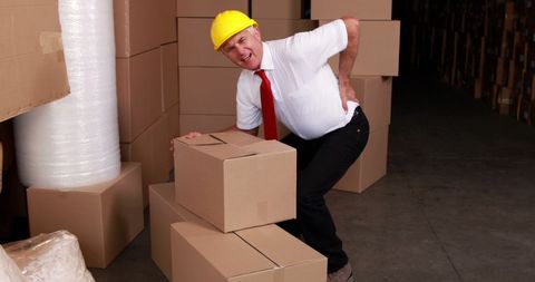 Warehouse Worker Experiencing Back Pain While Lifting Box - Download Free Stock Images Pikwizard.com