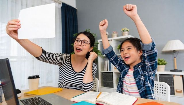 Mother and Daughter Celebrating Study Success During Remote Learning With Laptop