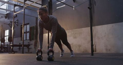 Woman Cross Training with Kettlebells in Gym Session