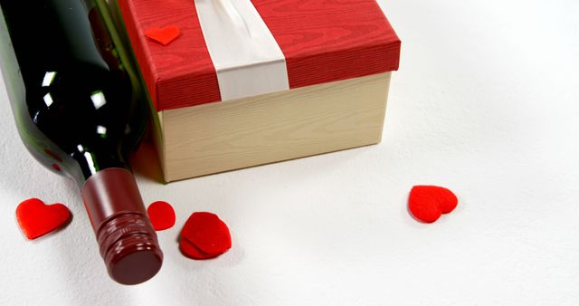 Wine bottle, gift box and red heart on white surface. Valentines day concept 4k
