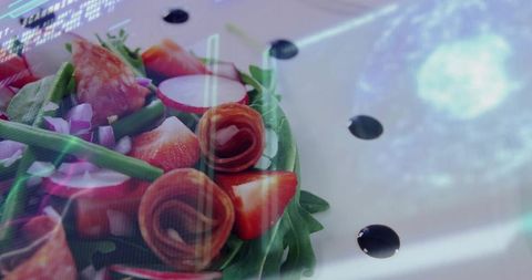 Arugula salad featuring charcuterie rosettes and strawberries on glossy reflective plate