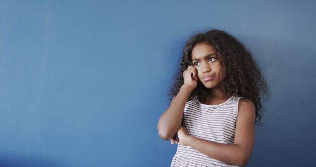 Frustrated Girl Expressing Discontent Against Blue Wall - Download Free Stock Images Pikwizard.com