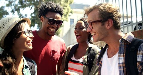 Diverse Friends Laughing Outdoors in Bright Sunlight