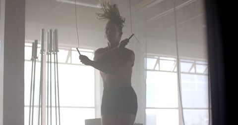 Strong Fit Woman with Prosthetic Leg Jumping Rope in Gym