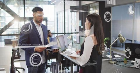 Colleagues Collaborating with Laptop and Documents in Modern Open-Plan Office HUD