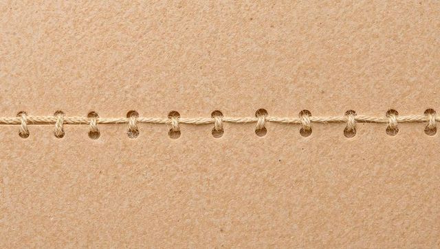 Kraft paper showing horizontal stitched seam with jute twine threading punched holes