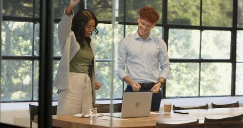 Diverse Colleagues Celebrating Success in Modern Office Workspace
