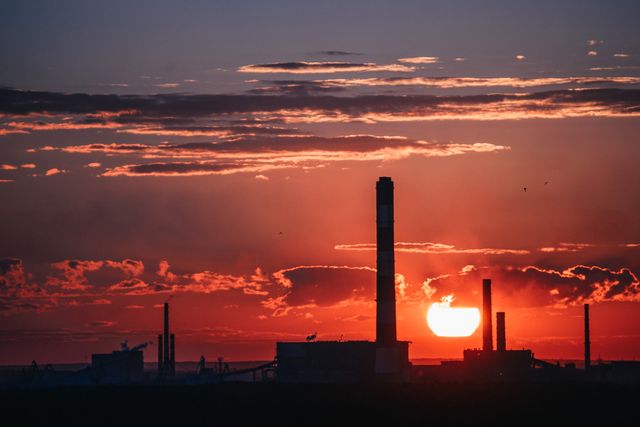 Bright Industrial Sunset Behind Factory Silhouette with Steam - Download Free Stock Photos Pikwizard.com