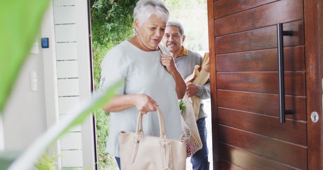 Senior couple returning home with groceries in eco-friendly bags - Download Free Stock Images Pikwizard.com