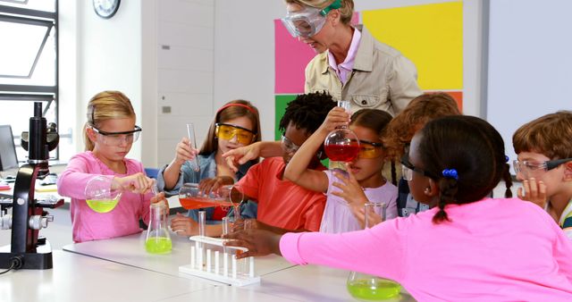 Diverse group of children conducting science experiments in a modern classroom under teacher's supervision. They are wearing safety goggles and using various lab equipment like beakers and test tubes. Ideal for depicting educational environments, science education, teamwork, STEM programs, and hands-on learning activities.