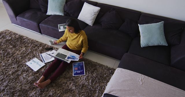 Young woman working from home analyzing financial reports - Download Free Stock Images Pikwizard.com