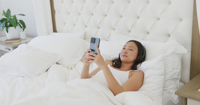 Woman Relaxing in Bed Using Smartphone in Bright Bedroom - Download Free Stock Images Pikwizard.com