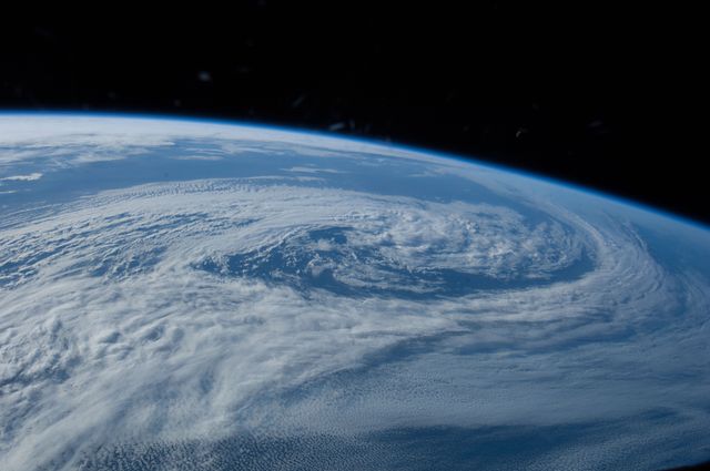 Cyclone spiraling over southern Pacific Ocean, captured from ISS on June 5, 2014. Demonstrates power of natural phenomena. Useful for climate and weather blogs, educational content on meteorology and atmospheric studies, satellite and space-related publications.