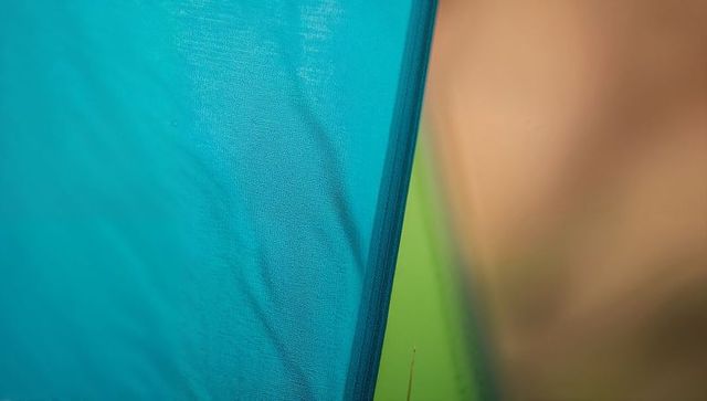 Teal fabric closeup with stitched seam and lime accent strip abstract textile texture