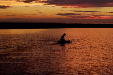 Silhouette of Man on Beach with Vibrant Sunset