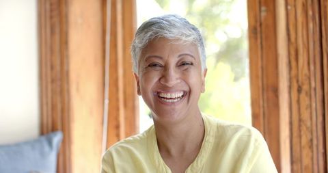 Smiling Senior Woman Relaxing at Home by Window