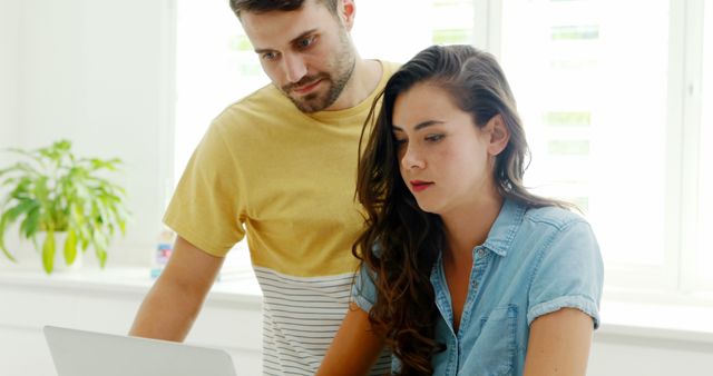 Young couple working together at home on laptop - Download Free Stock Images Pikwizard.com