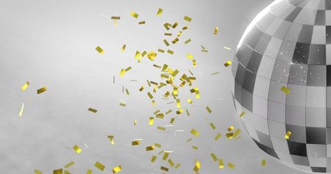 Golden confetti swirling around spinning disco ball celebration
