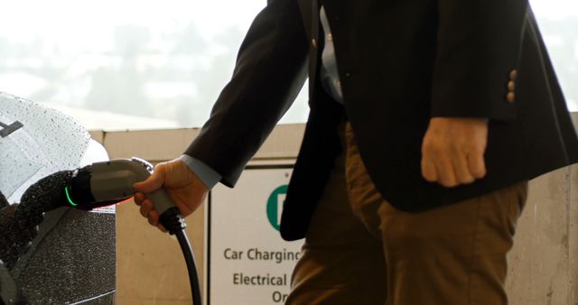 Close-up of man charging the electric car