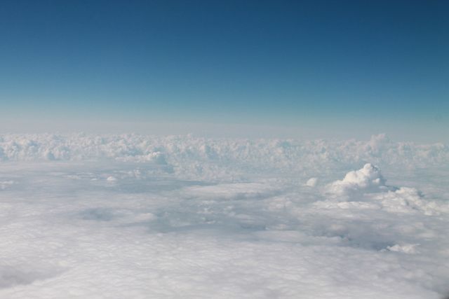 Serene Aerial View of Puffy Clouds Against Clear Blue Sky - Download Free Stock Photos Pikwizard.com