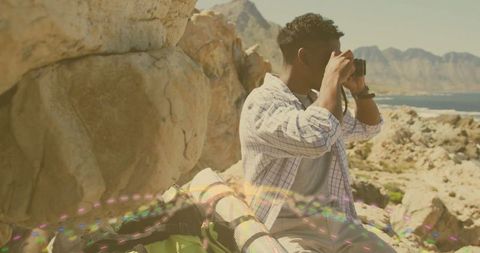 Young Hiker Observing from Rocky Ledge Near Scenic Sea