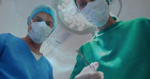 Surgeons performing surgery from patient perspective under surgical light in operating room