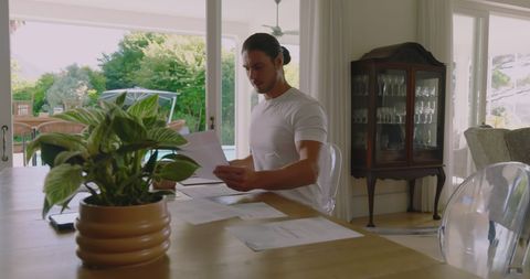 Businessman reviewing documents in bright home office setting