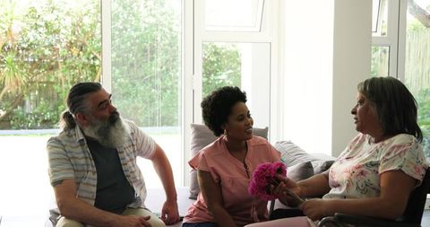 Senior Man Assisting Woman in Wheelchair Enjoying Conversation