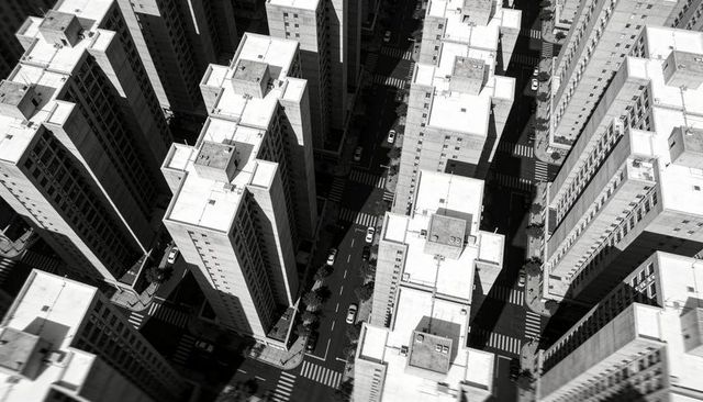 Monochrome aerial grid of downtown midrise towers with rooftop hvac, streets and shadows